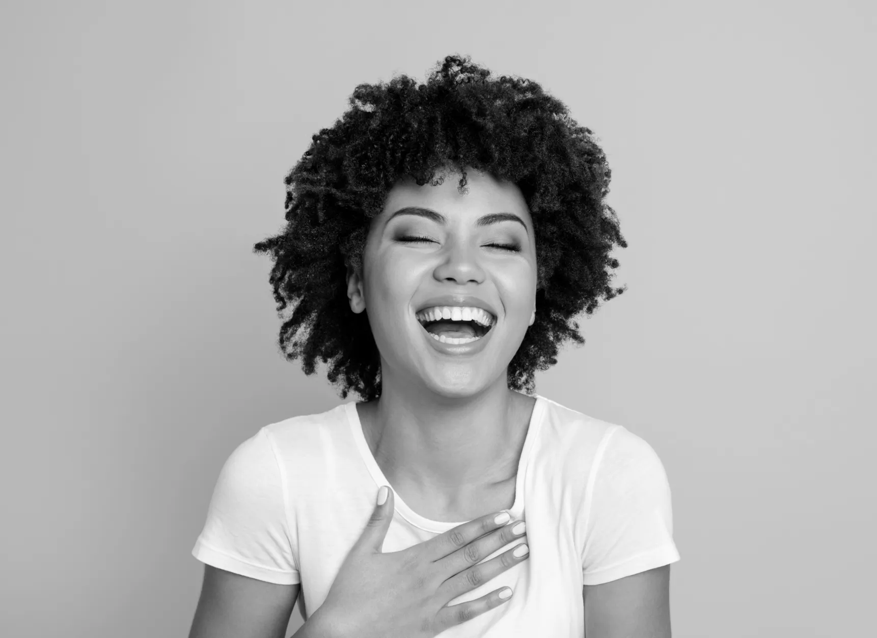 a woman smiling with her hands on her chest