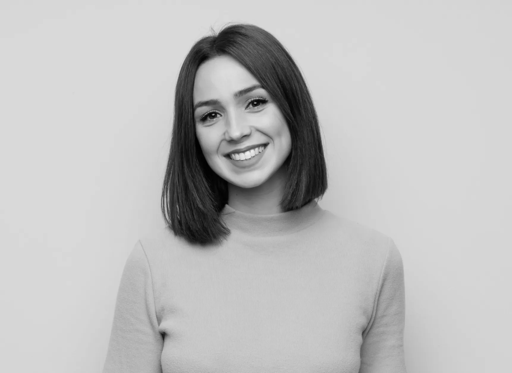 a black and white photo of a woman smiling