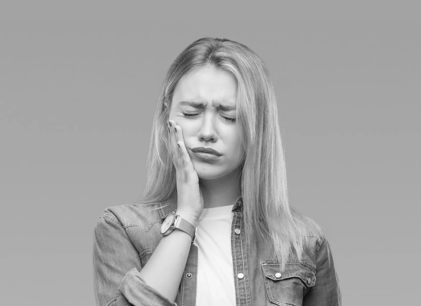 a woman holding her hand to her face